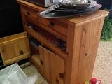 un micro-ondes posé sur un meuble en bois, à côté d'une poubelle