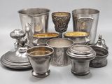 several silver cups and saucers are arranged on a table