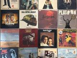 many different album covers on the wall of a room