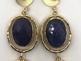 a close up of a pair of earrings on a white surface