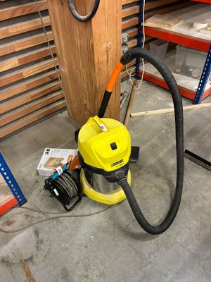 un aspirateur jaune et noir posé par terre dans un entrepôt