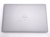 dell laptop computer sitting on a white surface with a dell logo on the screen