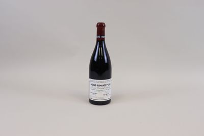 une bouteille de vin rouge posée sur une table blanche