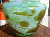 a green vase sitting on top of a wooden table