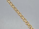 un bracelet à chaîne en or avec une breloque en forme de cœur