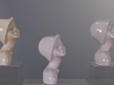 three different sculptures on display in a glass case