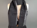 a black scarf with fringes on a mannequin mannequin