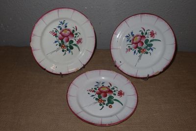 trois assiettes ornées de fleurs posées sur une table