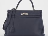 un sac à main en cuir bleu muni d'un fermoir métallique sur la poignée