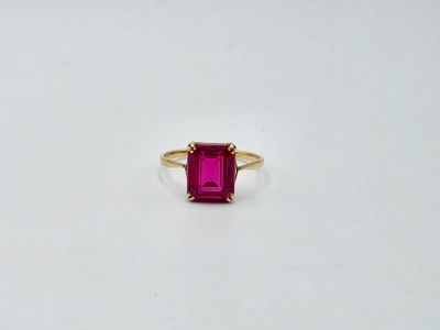 une bague en tourmaline rose avec un anneau en or sur un fond blanc