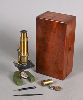 une boîte en bois sur laquelle sont posés un microscope et d'autres objets