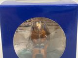 a small figurine in a blue box on a white surface