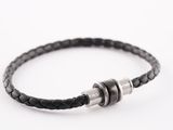 un gros plan sur un bracelet en cuir noir muni d'un fermoir en argent