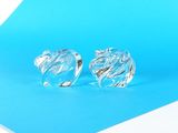 une paire de boucles d'oreilles en verre transparent sur fond bleu