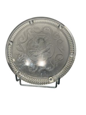 a silver plate with a picture of a woman on it
