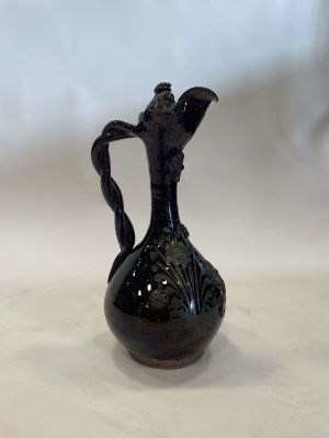 a black vase that is sitting on a table