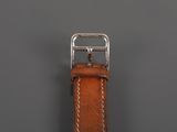 a close up of a brown leather watch strap with a silver buckle