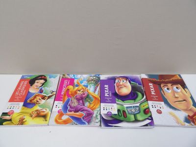 four disney and pixa books are lined up on a table
