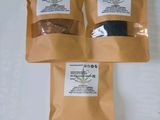 three bags of spices sitting on top of a white table