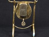 an image of a brass bell on a stand with a blue toothbrush