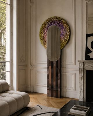 un salon avec un canapé et un miroir accroché au mur
