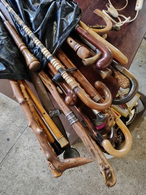 many different types of umbrellas and canes on a table