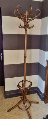 a coat rack in the corner of a room with a striped wall