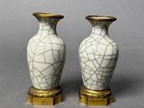 pair of white and gold vases sitting on top of a table