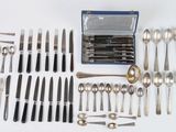 a lot of silverware on a white table