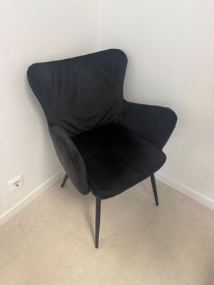 une chaise noire placée dans un coin d'une pièce