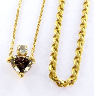 a close up of a necklace and a chain with a heart on it