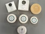 quatre pains de savon, des pains de savon et un porte-savon posés sur une table