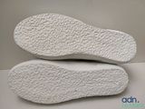the soles of a pair of white shoes on a white surface