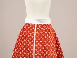 La jupe est confectionnée dans un tissu à imprimé Louis Vuitton orange et blanc.