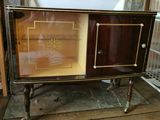 une armoire avec une porte vitrée posée sur un parquet