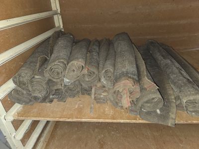 de nombreux rouleaux de tissu posés sur une étagère dans une pièce