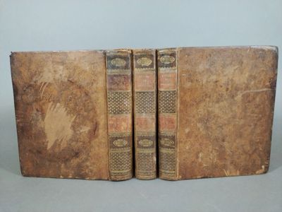 two old books sitting on top of each other on a table