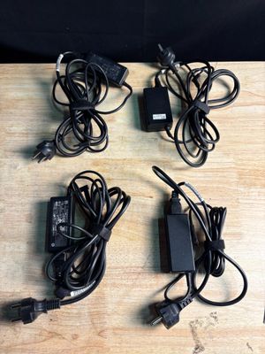 a lot of power cords and a charger on the table