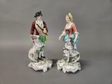 pair of porcelain figurines of a man and a woman with a dog
