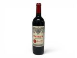 a bottle of red wine sitting on top of a white table