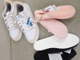 three pairs of shoes that are sitting on a couch