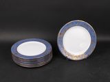 six assiettes bleues et blanches à bord doré sur fond noir