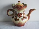 a brown and red vase sitting on a white table