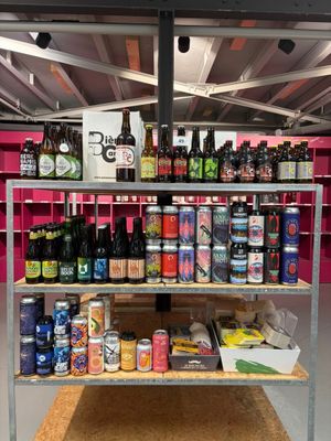 une étagère remplie de bouteilles et de canettes de bière dans une pièce