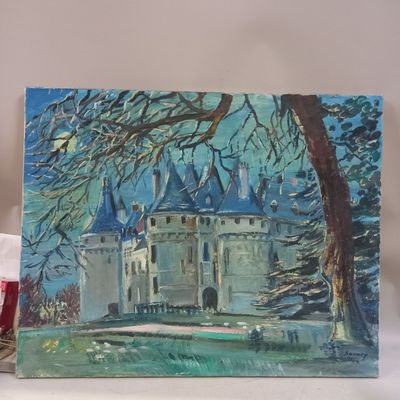 a painting of a castle on a table next to a candle