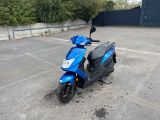 un scooter bleu garé sur un parking