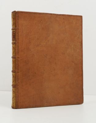 an old book with a brown cover sitting on top of a white table