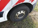 a close up of a red and white bus tire