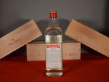 a bottle of alcohol sitting on a table next to a wooden box