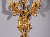 a gold and blue wall sconce with candles on it